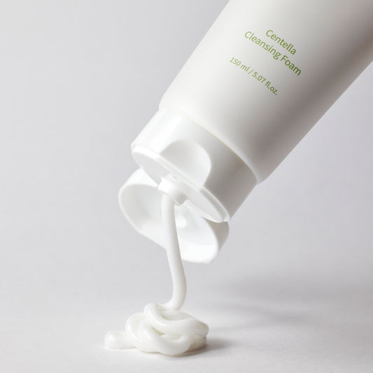 Centella Asiatica Foaming Cleanser in white tube dispensing foam on a white surface.