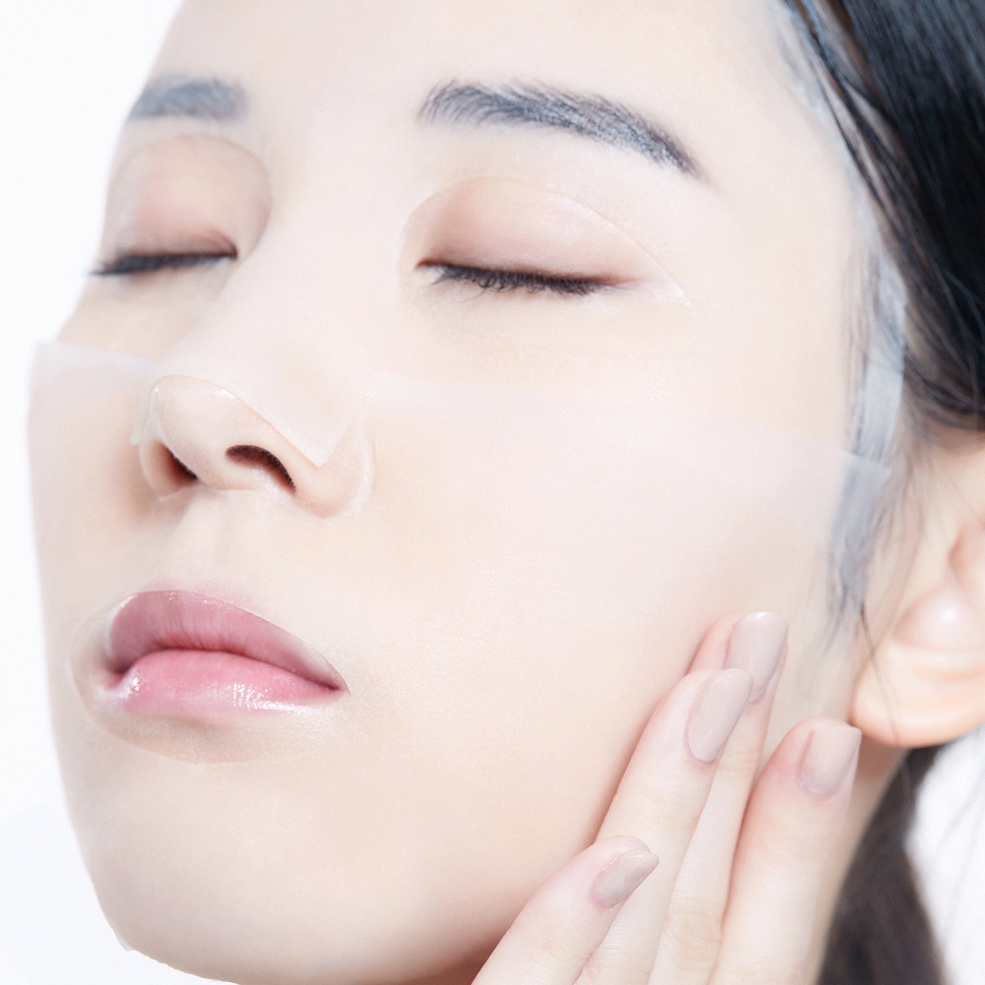 Close-up of a person wearing a Centella Asiatica mask sheet on their face, with eyes closed.