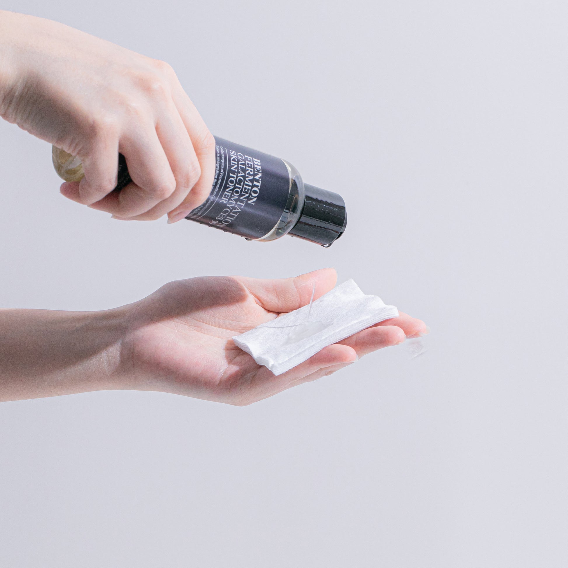 Benton Fermentation Galactomyces 99 Skin Toner being poured onto a cotton pad from a bottle.
