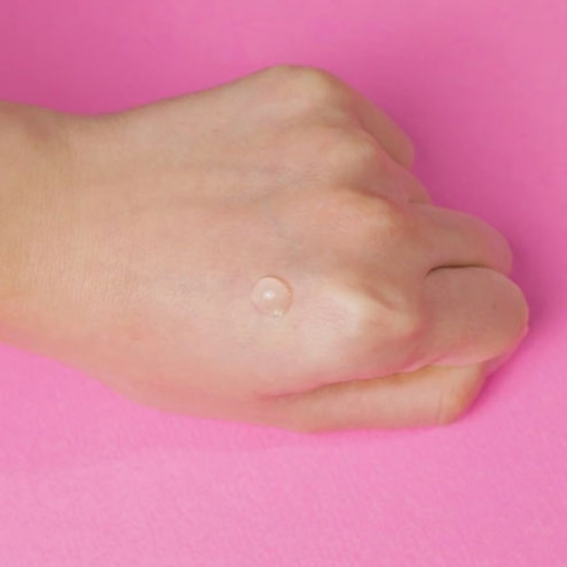 Drop of COSRX Goodbye Redness Centella Cica Gel on hand with pink background