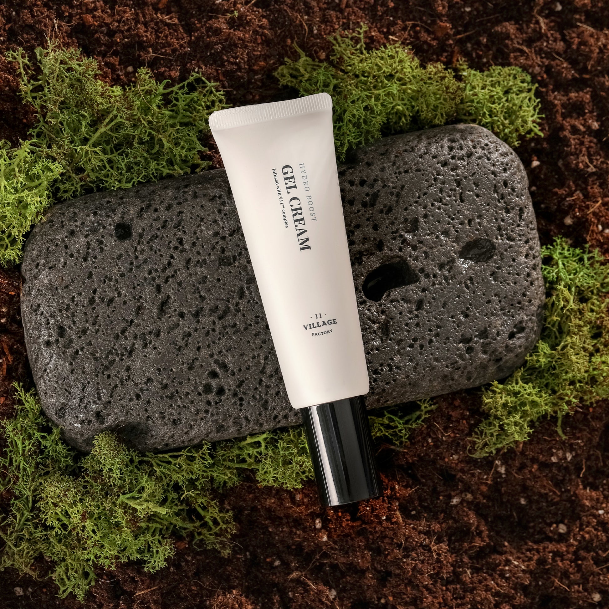 Village 11 Factory Hydro Boost Gel Cream on pumice stone with moss and soil background.