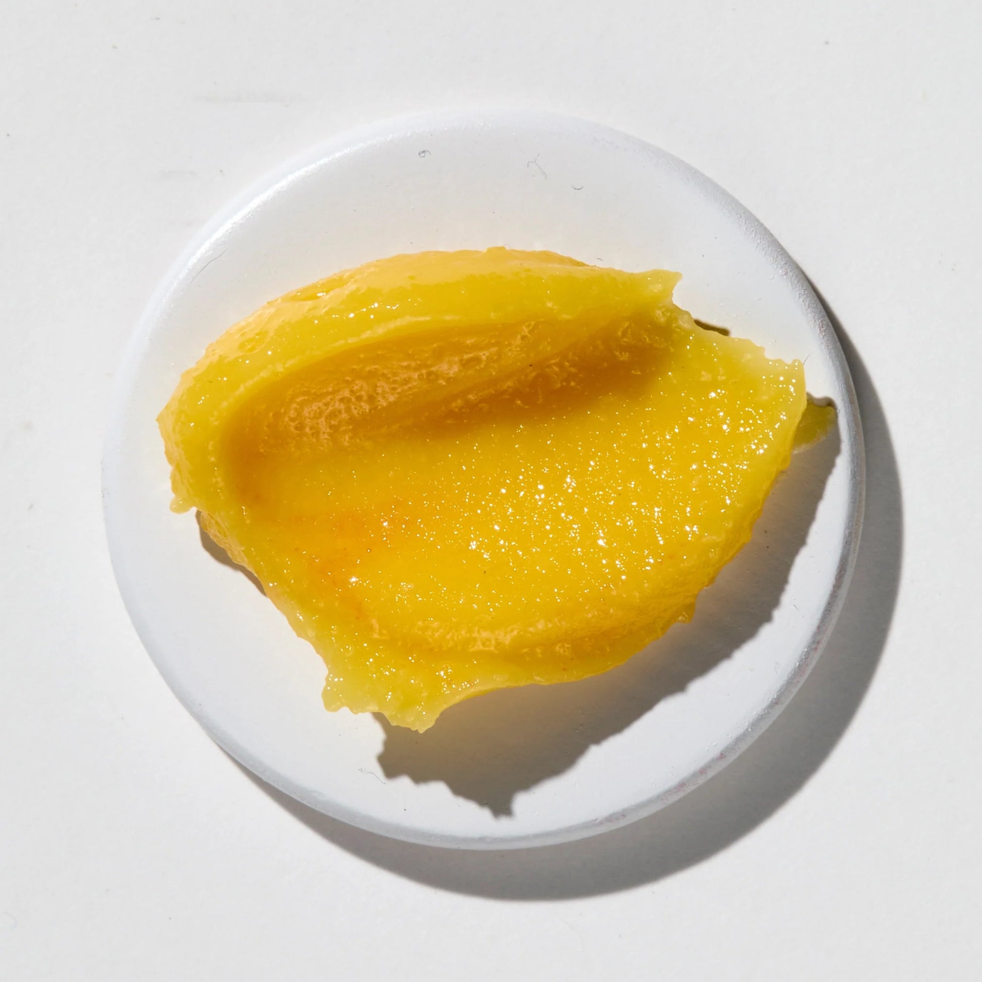 Vanessa Megan Mandarin & Basil Hydrating Lip Balm on a white plate with a white background