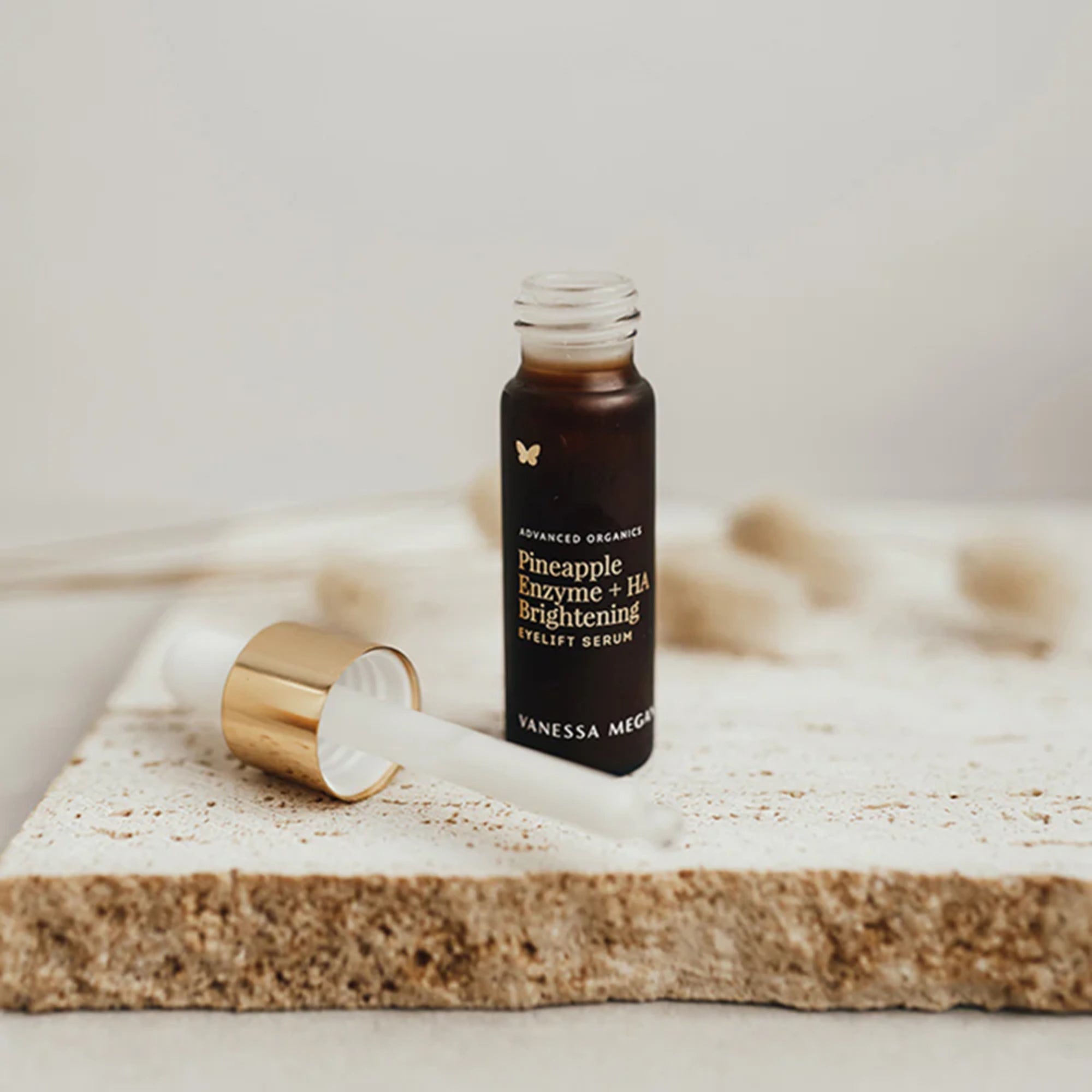 Vanessa Megan Pineapple Enzyme + HA Brightening Eyelift Serum bottle on a marble surface with a blurred background