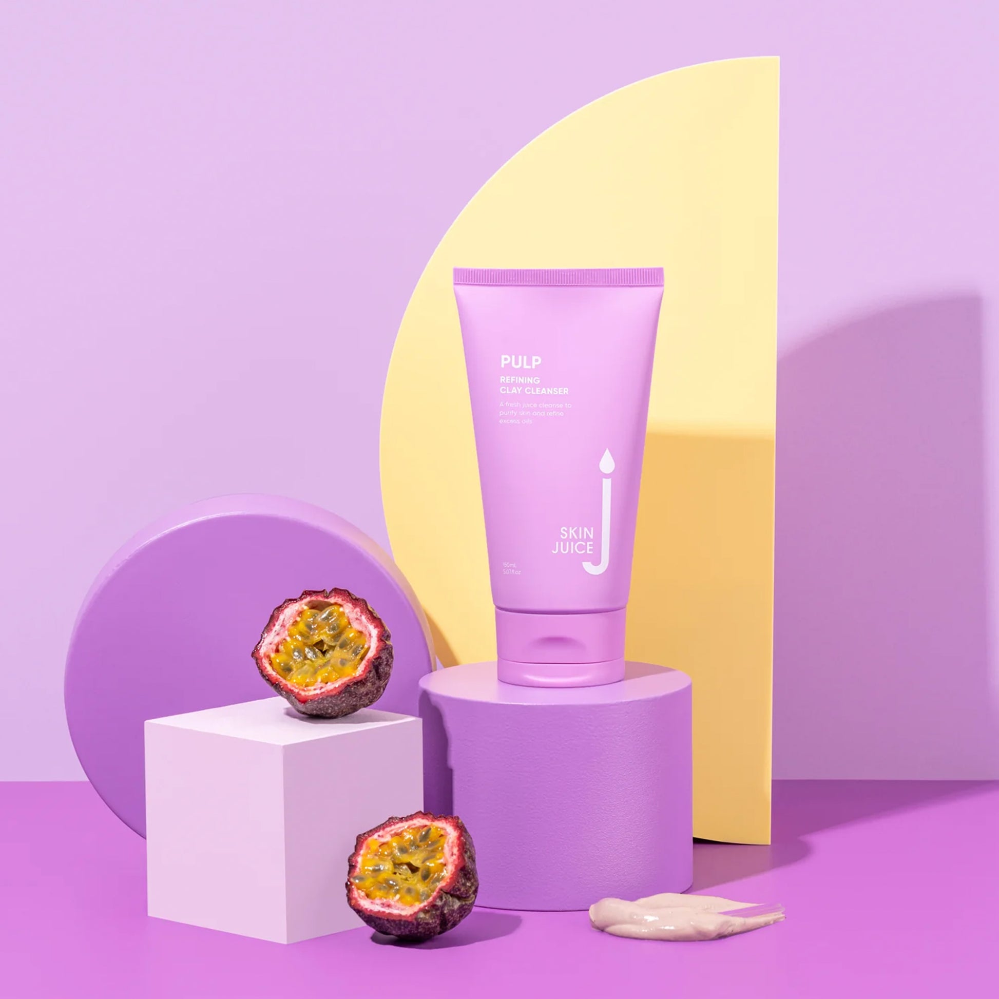 Skin Juice Pulp Refining Clay Cleanser tube with passion fruit on colorful geometric display.