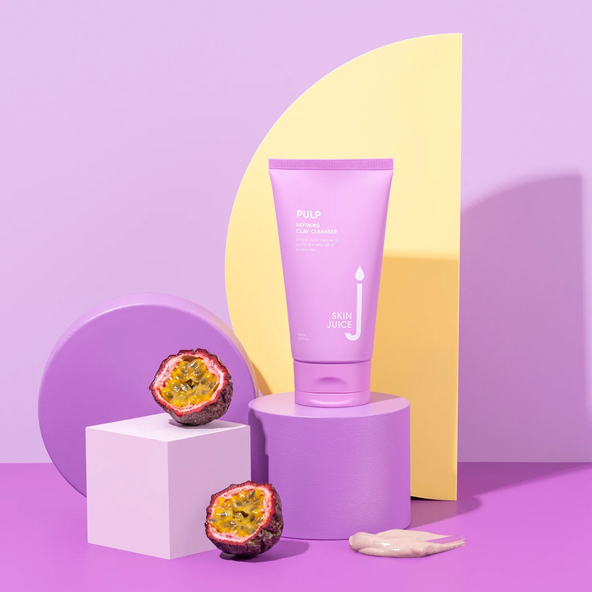 Skin Juice Pulp Refining Clay Cleanser tube with passion fruit on colorful geometric display.
