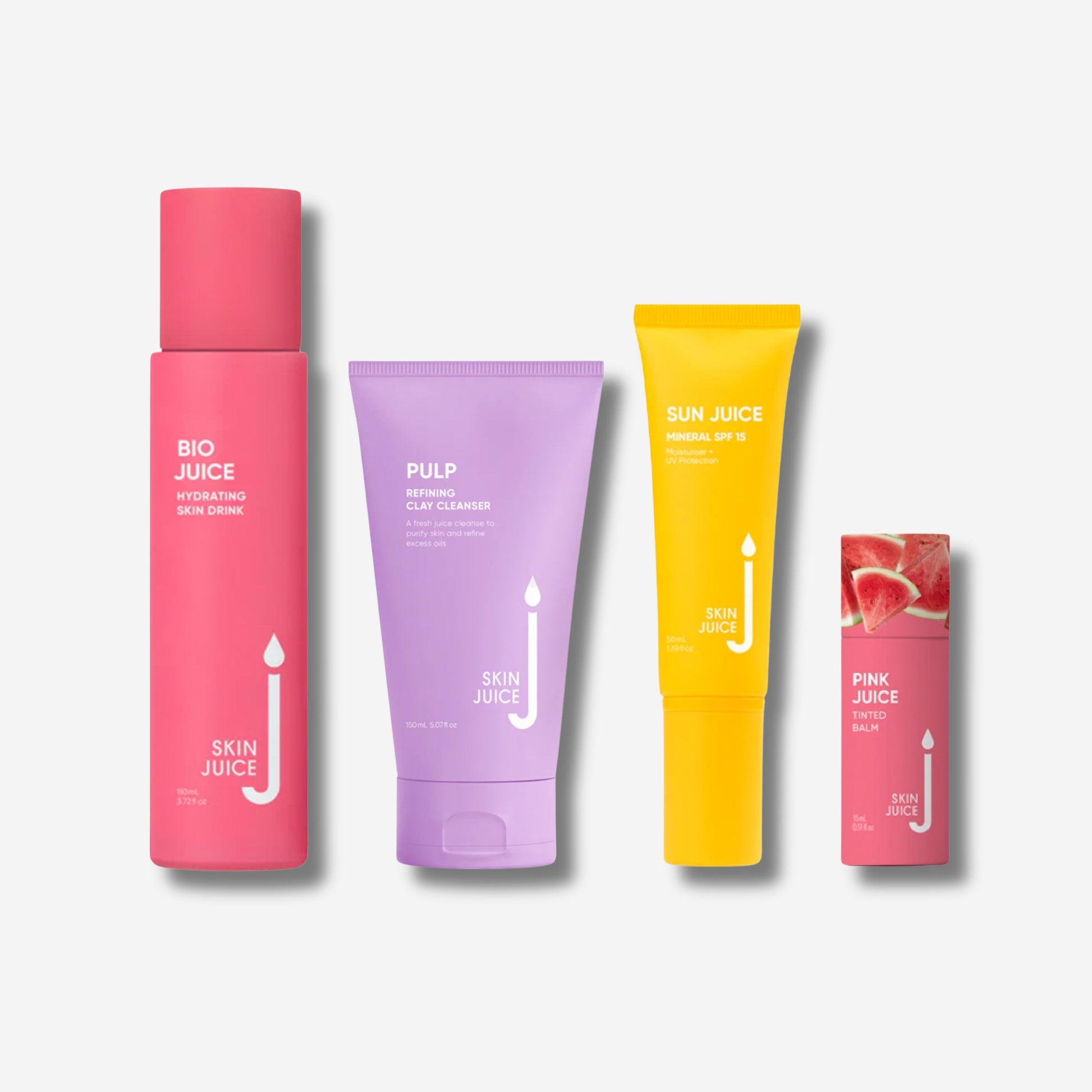 Four Skin Juice products on a white background. From left to right: a pink bottle labeled 'Bio Juice Hydrating Skin Drink,' a purple tube labeled 'Pulp Refining Clay Cleanser,' a yellow tube labeled 'Sun Juice Mineral SPF 15,' and a pink tinted balm stick with watermelon imagery labeled 'Pink Juice.'