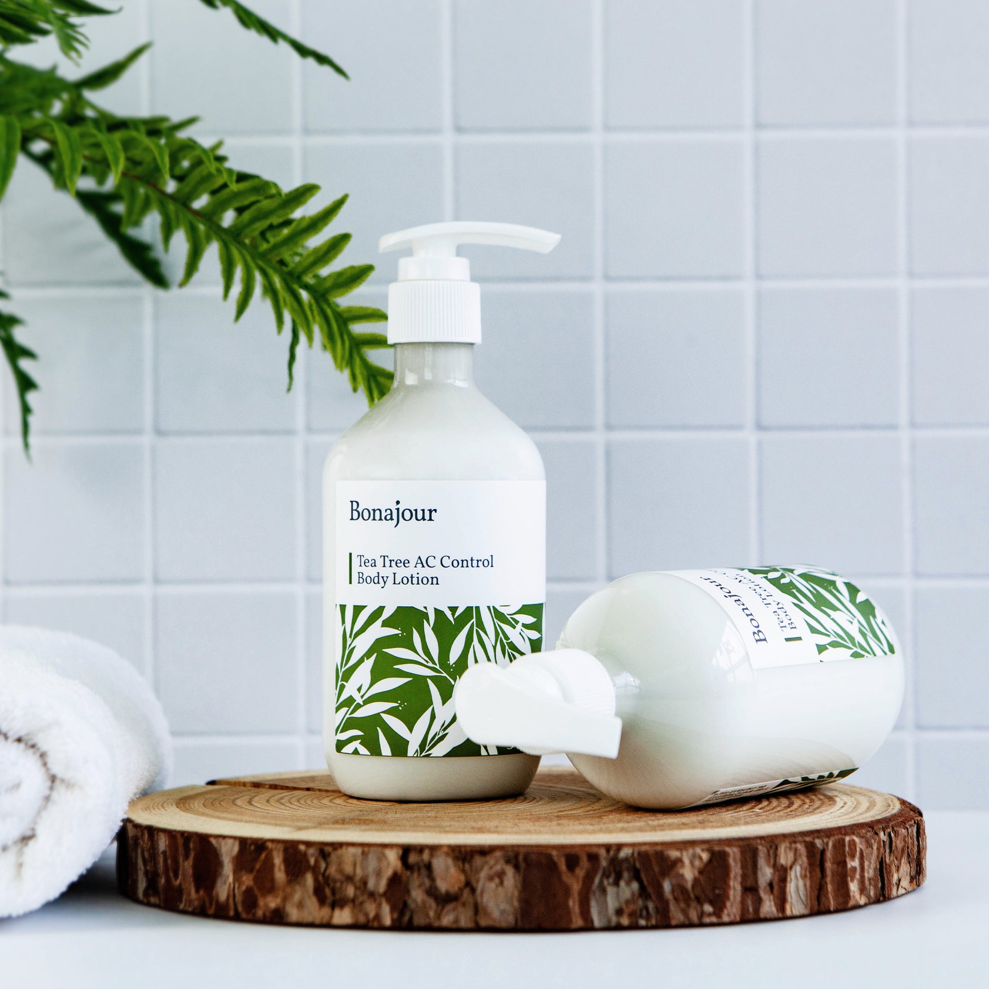 Bonajour Tea Tree AC Control Body Lotion on wood tray in bathroom with plant