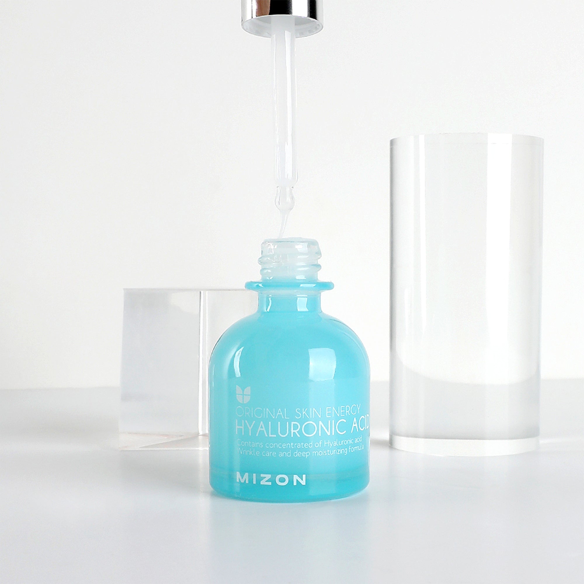 Mizon Hyaluronic Acid serum bottle with dropper, clear cylinder cap beside it.