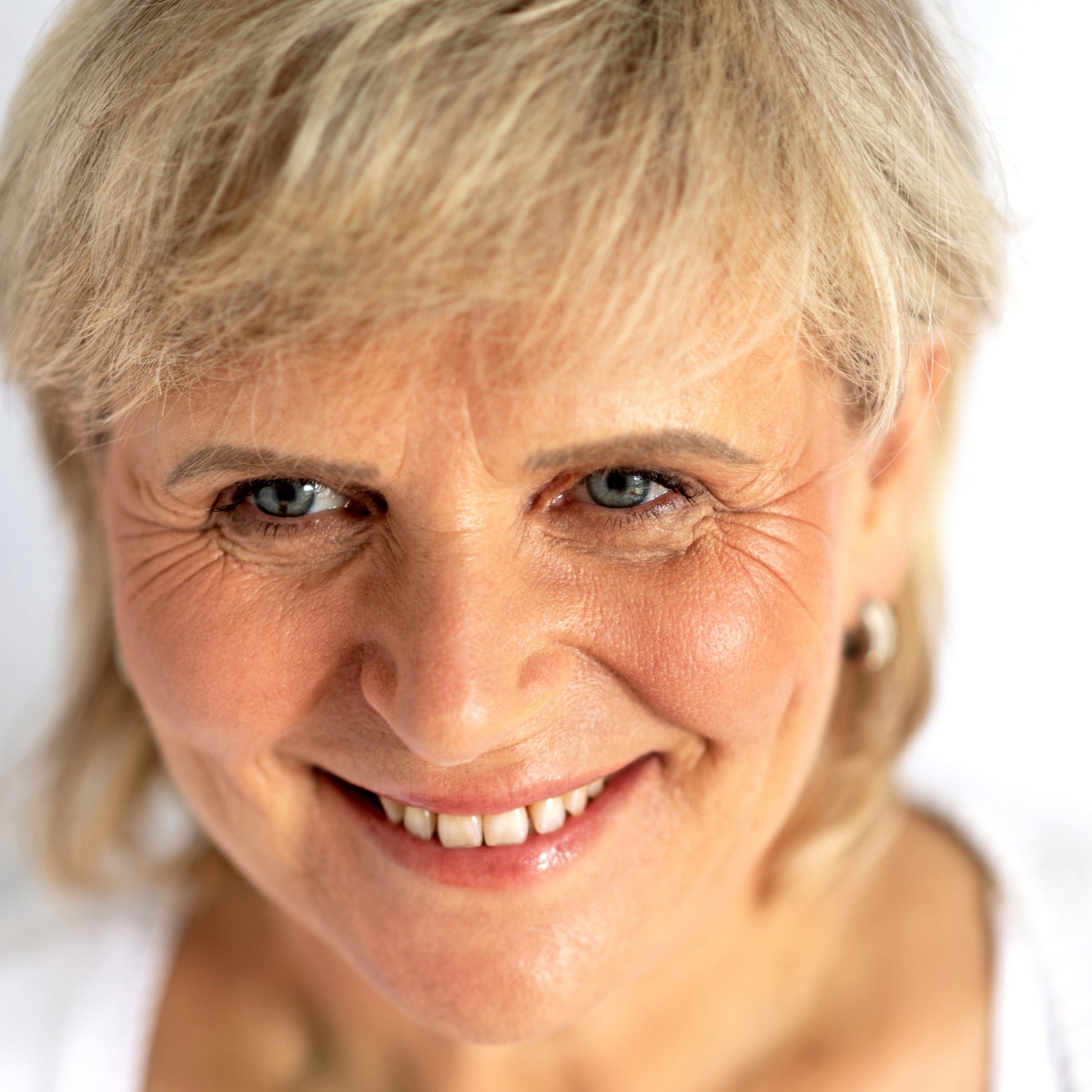 A smiling lady with Ere Perez blush in Brooklyn colour