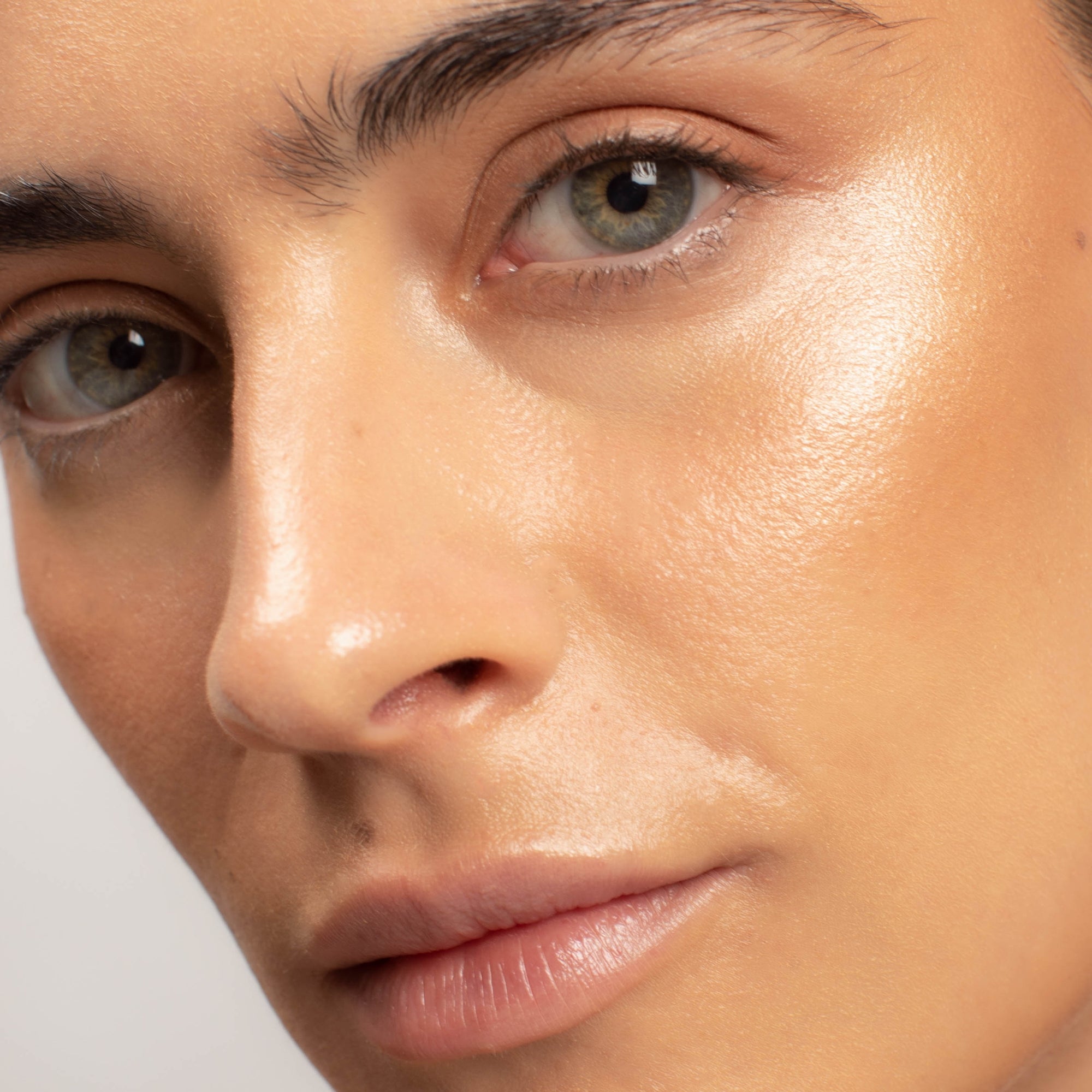 Close-up of a person's face highlighting smooth, glowing skin, showcasing the subtle effect of applied rice powder blush.