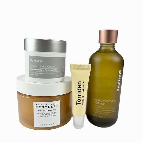 Four products from the Skin Rescue Kit placed on a white background, featuring a cream jar, an essence bottle, and two small tubes—ideal for anyone looking to establish an effective dry skin skincare routine.